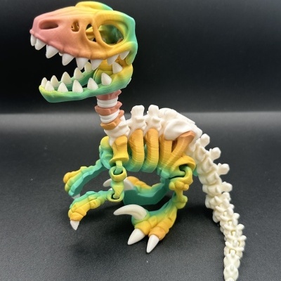 Figura de dinossauro esqueleto de plástico colorido com detalhes em branco e degradê colorido