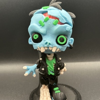 Figura colecionável de zumbi azul com roupa preta e verde em suporte preto