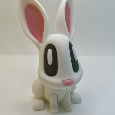 Boneco de coelho branco com olhos grandes pretos e orelhas cor de rosa