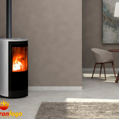 Lareira estufa moderna em metal com fogo visível, em sala com decoração minimalista.