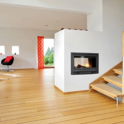 Sala com chão em madeira clara, lareira embutida, escada e cadeira vermelha