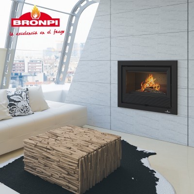 Lareira embutida da Bronpi com fogo numa sala moderna com sofá branco e mesa rústica