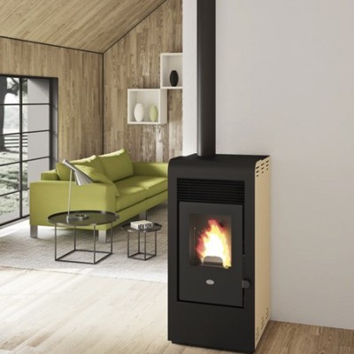 Lareira a pellets preta com fogo, sofá verde, mesas de centro pretas e parede de madeira