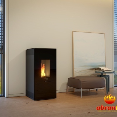 Lareira a pellets preta com chama visível numa sala moderna com janela grande e banco ao lado