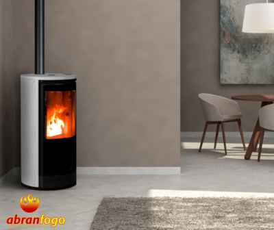 Lareira estufa moderna em metal com fogo visível, em sala com decoração minimalista.