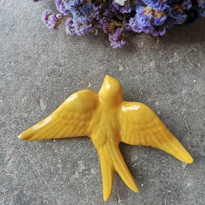 Andorinha amarelo canário em cerâmica