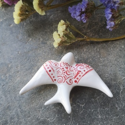 Andorinha rendas vermelhas em cerâmica