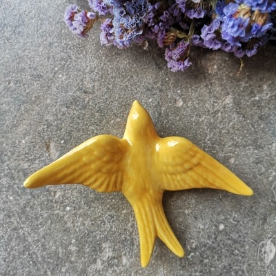 Andorinha amarelo canário em cerâmica