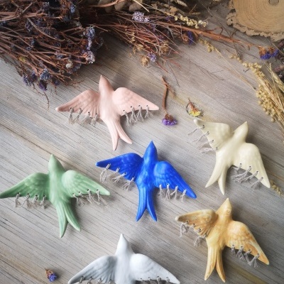 Andorinha azul mate em cerâmica com macramé decorativo