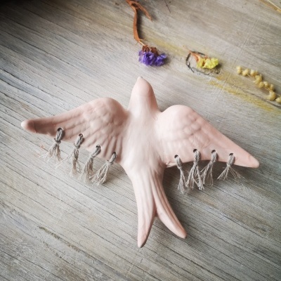 Andorinha rosa mate em cerâmica com macramé decorativo
