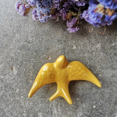 Andorinha amarelo canário em cerâmica