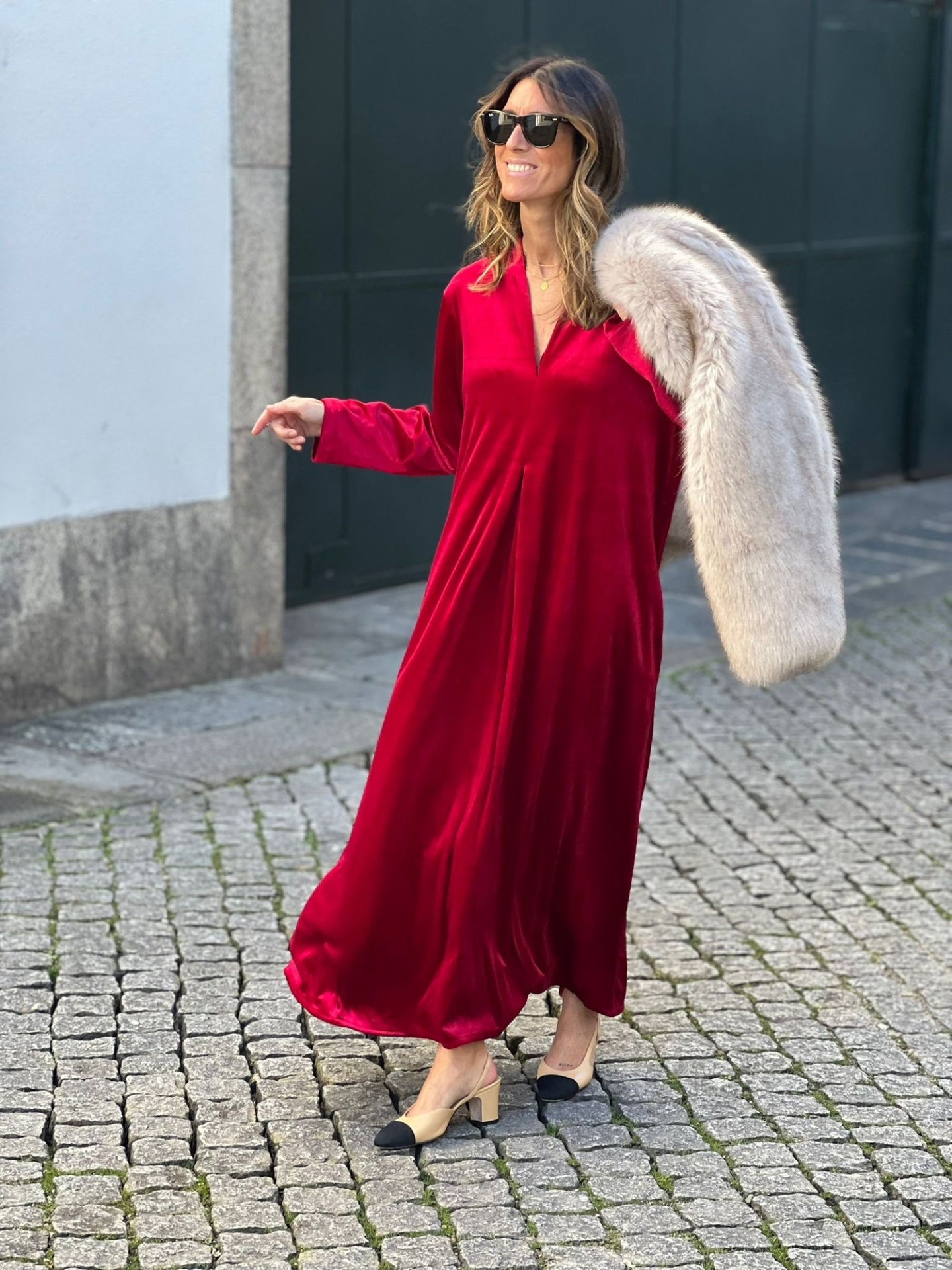 VESTIDO NATACHA VERMELHO Mulher com vestido longo vermelho e casaco peludo cinzento ao ombro