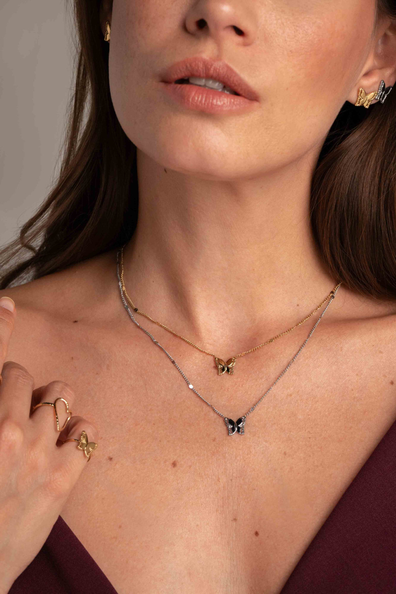FIO BORBOLETA Colar duplo, brincos e anéis com pendentes de borboleta em mulher