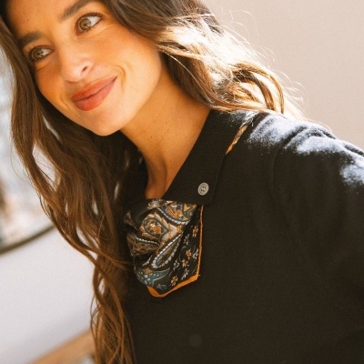 Mulher com camisola preta e lenço estampado ao pescoço