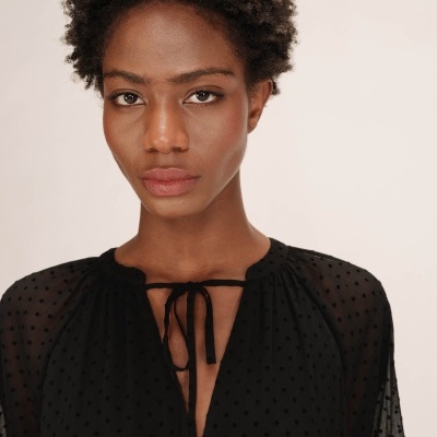 Blusa preta transparente com padrão de bolinhas e cordão no decote