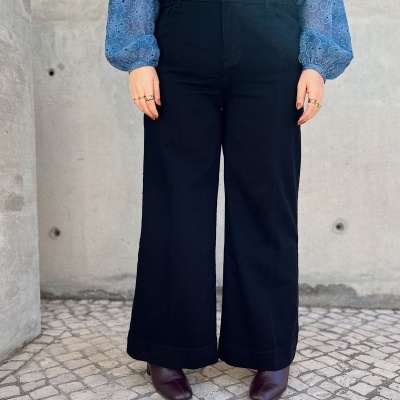 Calças pretas de corte largo com camisa azul e botas castanhas