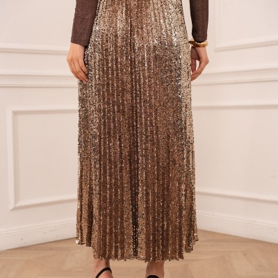Saia plissada com lantejoulas douradas e sapatos pretos de salto alto