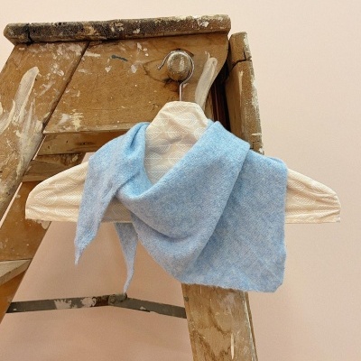 Lenço azul claro pendurado em cabide de madeira num escadote rústico
