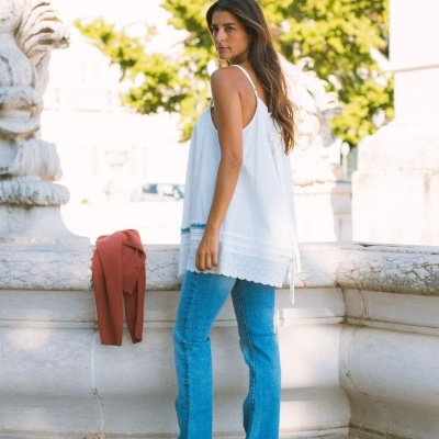 Mulher com blusa branca e calças de ganga em ambiente urbano