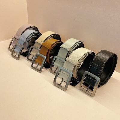 Cintos de couro em várias cores alinhados sobre superfície clara