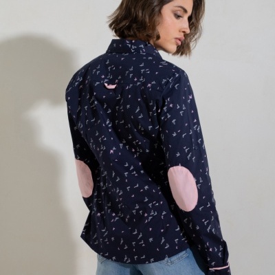 Camisa azul escura com pequenos símbolos brancos e rosa, cotoveleiras rosas, usada por mulher vista de costas