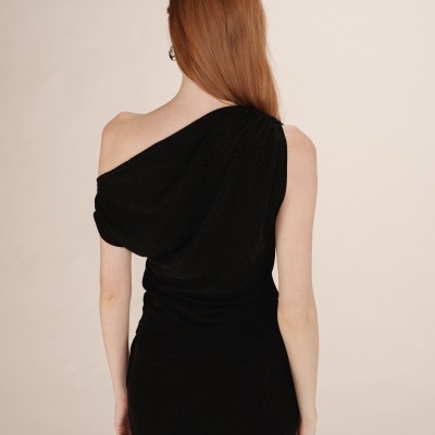 Top preto brilhante de um ombro só e calças pretas vista de trás