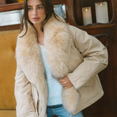 Casaco bege com gola de pelo sintético creme usado por mulher