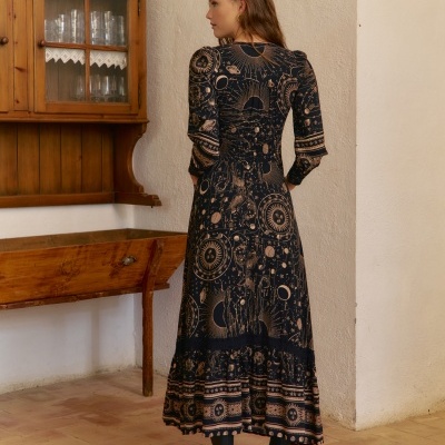 Vestido comprido com padrão astronómico em tons castanhos e pretos, mangas compridas e folho na saia