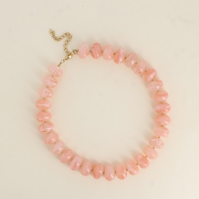 Colar de contas rosa translúcido com fecho dourado sobre fundo branco