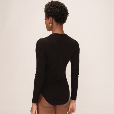 Modelo com body preto de manga comprida vista de costas