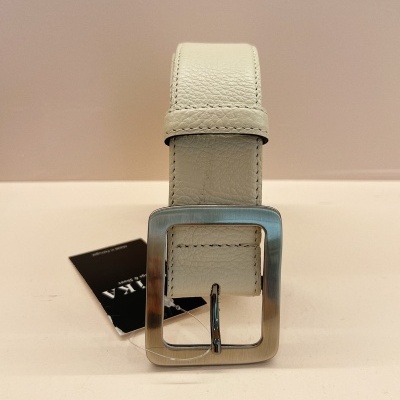 Cinto branco de pele com fivela quadrada metálica sobre superfície creme