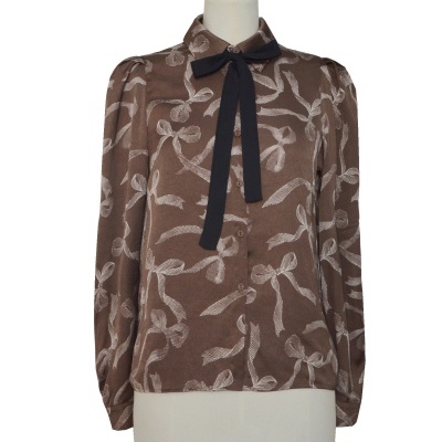 Camisa castanha com padrão de laços e laço preto na gola