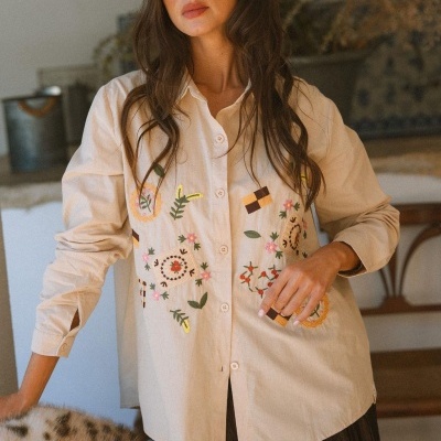 Camisa bege com bordados florais coloridos e botões frontais