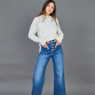 Mulher com sweater branco e calças de ganga azuis com botões e sapatos vermelhos de salto alto