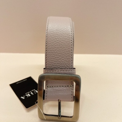 Cinto bege claro de pele com fivela metálica quadrada prateada sobre superfície bege