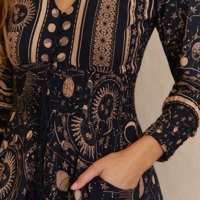 Vestido com padrão celestial em tons creme e fundo preto com botões e bolso lateral