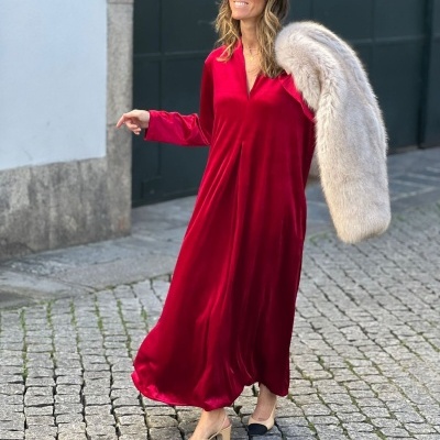 Mulher com vestido longo vermelho e casaco peludo cinzento ao ombro