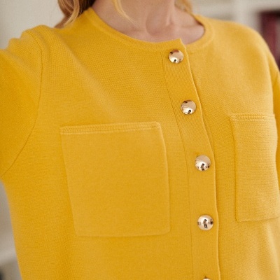 Camisola amarela com botões dourados e bolsos frontais