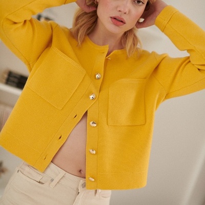 Cárdigan amarelo com botões dourados e dois bolsos frontais em tecido de malha