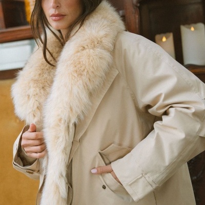 Casaco bege com gola de pelo sintético creme em ambiente interior
