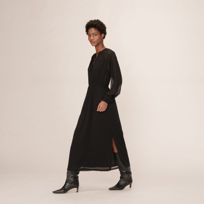 Vestido preto comprido com pequenos pontos e botas pretas