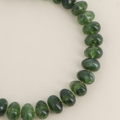 Colar com contas verdes translúcidas e pequenas esferas douradas