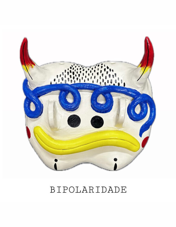 SOB A PELE: " MÁSCARAS DA MENTE " MARTA PINTO Máscara decorativa branca com chifres vermelhos e detalhes azuis, olhos pretos e boca amarela curvada para baixo