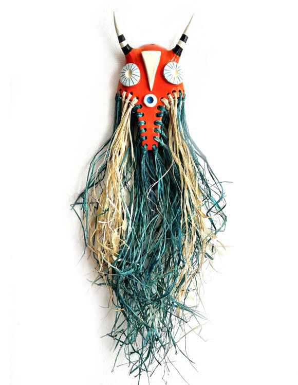 MÁSCARA " AZERBAIJÃO " MARTA PINTO Máscara decorativa vermelha com olhos azuis e franjas bege e azul