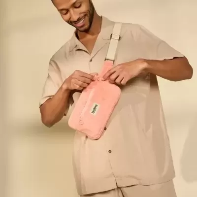 Mala pochete cor-de-rosa com etiqueta BROOKLYN usada por homem vestido de bege