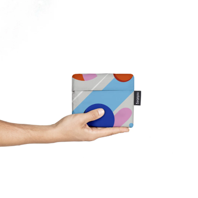 Carteira dobrável colorida em padrão geométrico segura numa mão