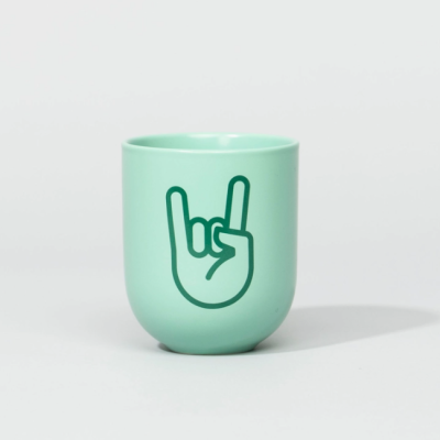 Copo verde claro com desenho de mão a fazer gesto rock