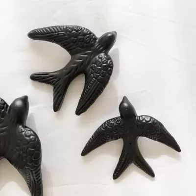 Figuras decorativas de pássaros pretos com textura detalhada em superfície branca