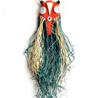 Máscara decorativa vermelha com olhos azuis e franjas bege e azul