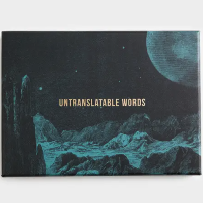 Livro de capa dura com título UNTRANSLATABLE WORDS e paisagem lunar azul e negra